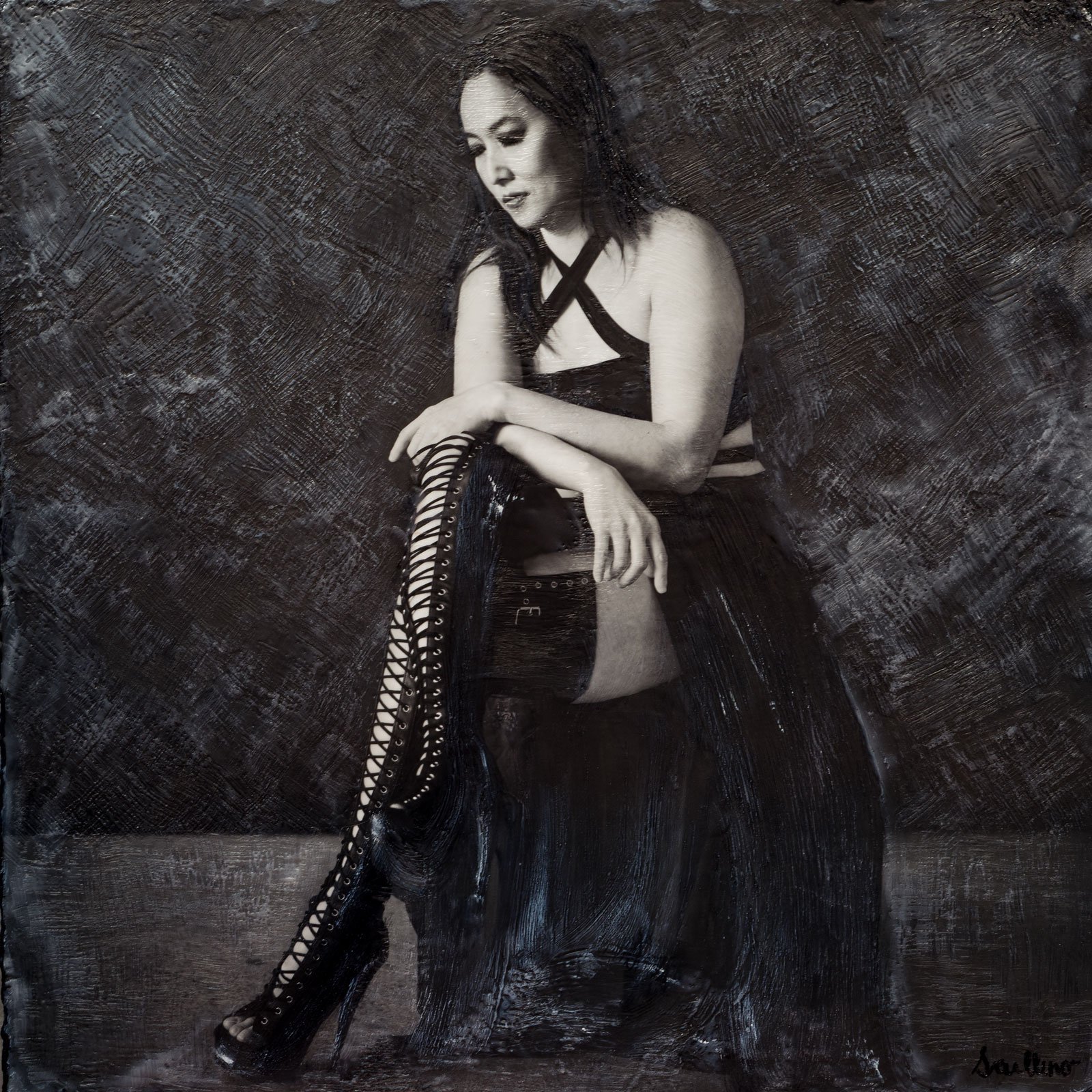 Portrait mixte en noir et blanc d'une femme assise sur un tabouret, portant un haut à bretelles et des bottes hautes, par Jerome Art Photography.