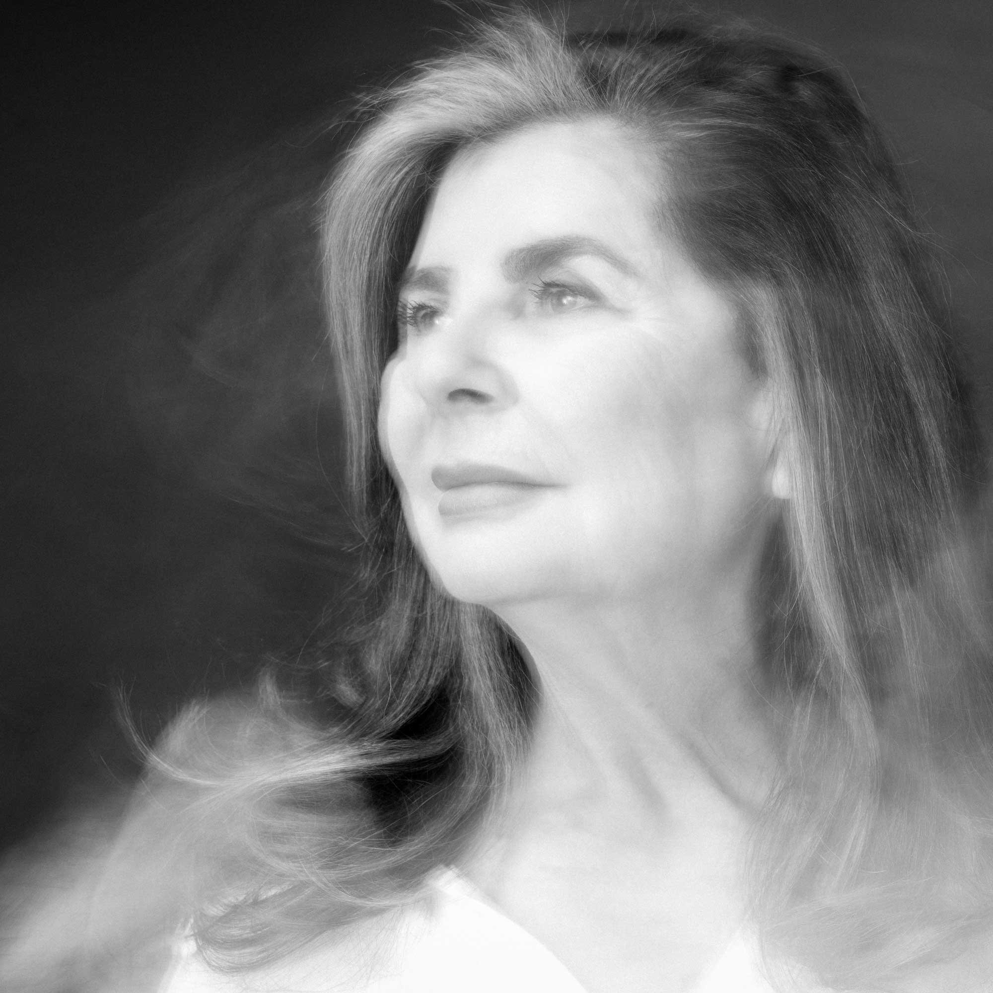 Portrait éthéré en noir et blanc d'une femme d'âge mûr, avec un éclairage doux et rêveur et une douce expression, par Jerome Art Photography.